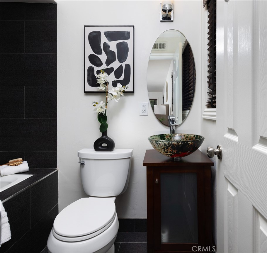 14191 Lambeth Way Tustin, CA 92780 - Photo 24 of 34 a bathroom with a toilet a sink and mirror