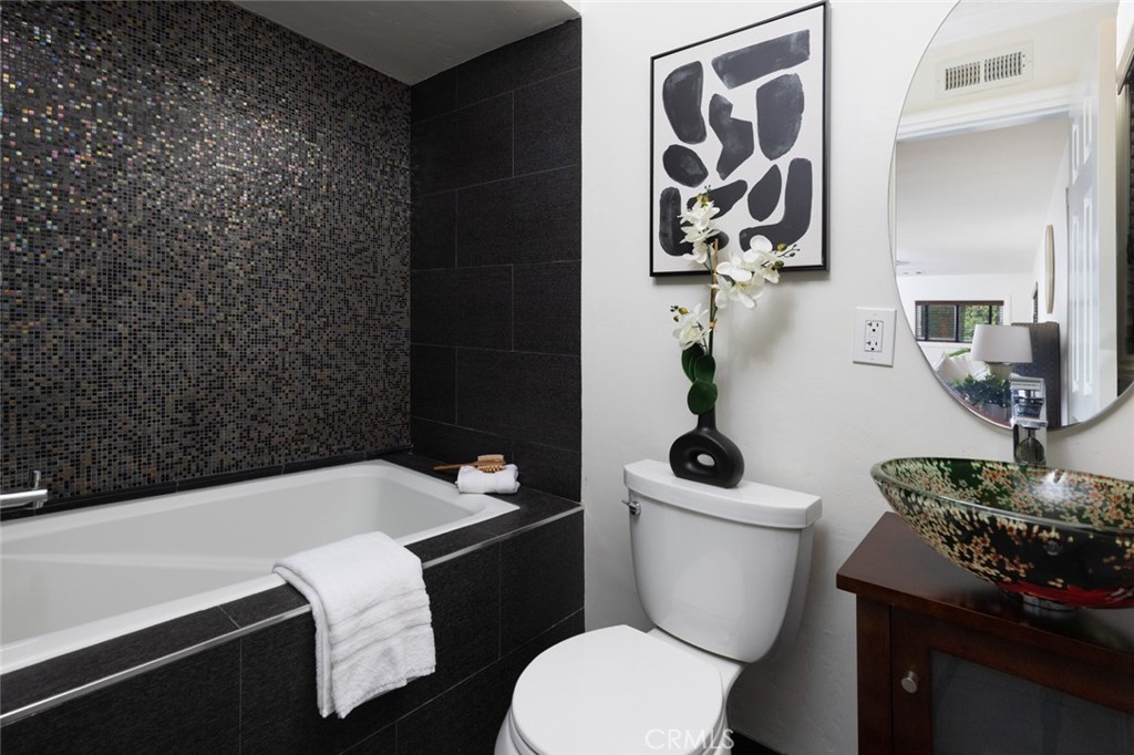 14191 Lambeth Way Tustin, CA 92780 - Photo 25 of 34 a bathroom with a sink a toilet and a mirror