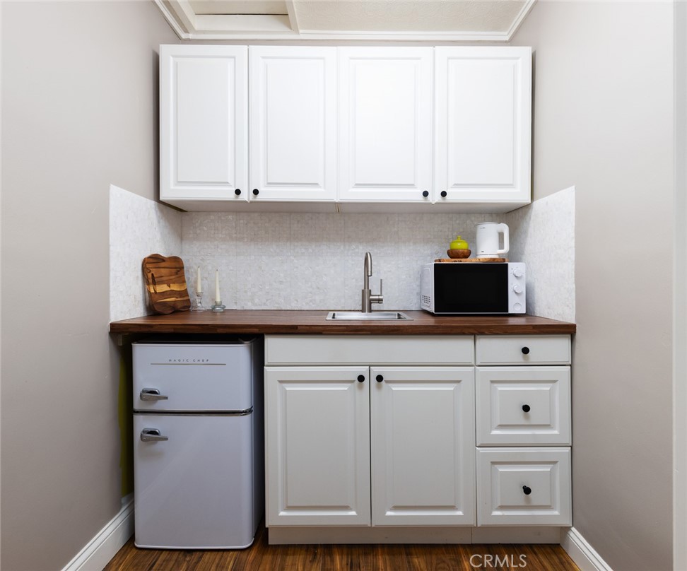 14191 Lambeth Way Tustin, CA 92780 - Photo 27 of 34 a kitchen with white cabinets and white appliances