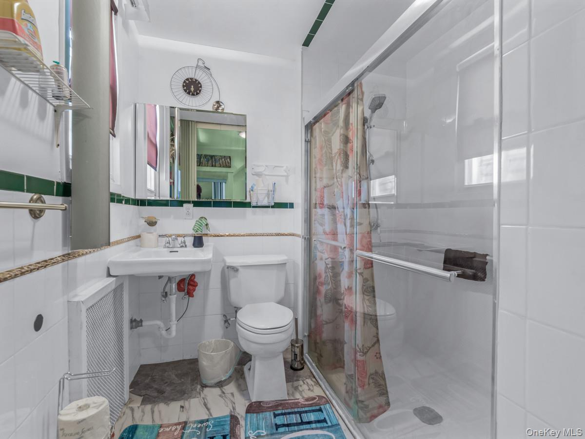 27-21 Coldspring Road Queens, NY 11691 - Photo 11 of 27 a bathroom with a sink toilet and shower