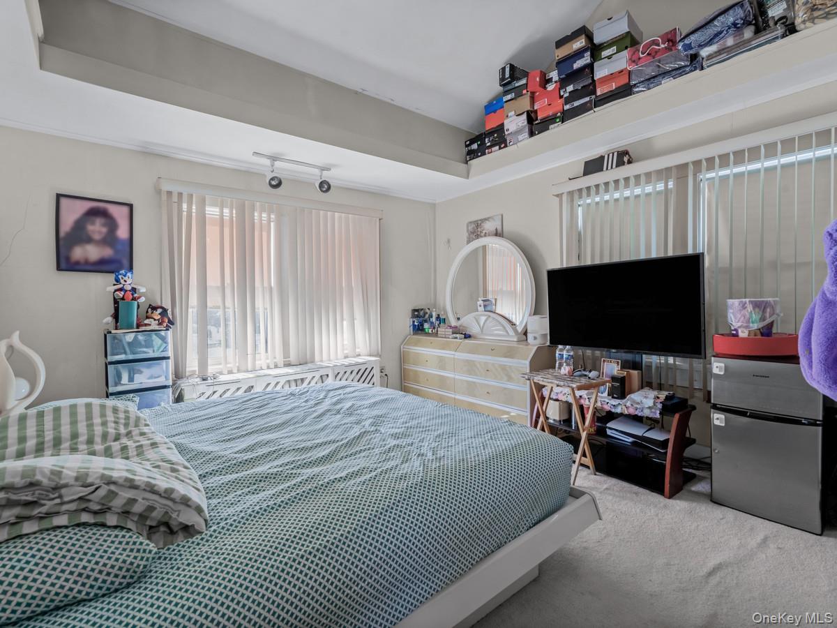 27-21 Coldspring Road Queens, NY 11691 - Photo 12 of 27 a bedroom with a bed and a flat screen tv