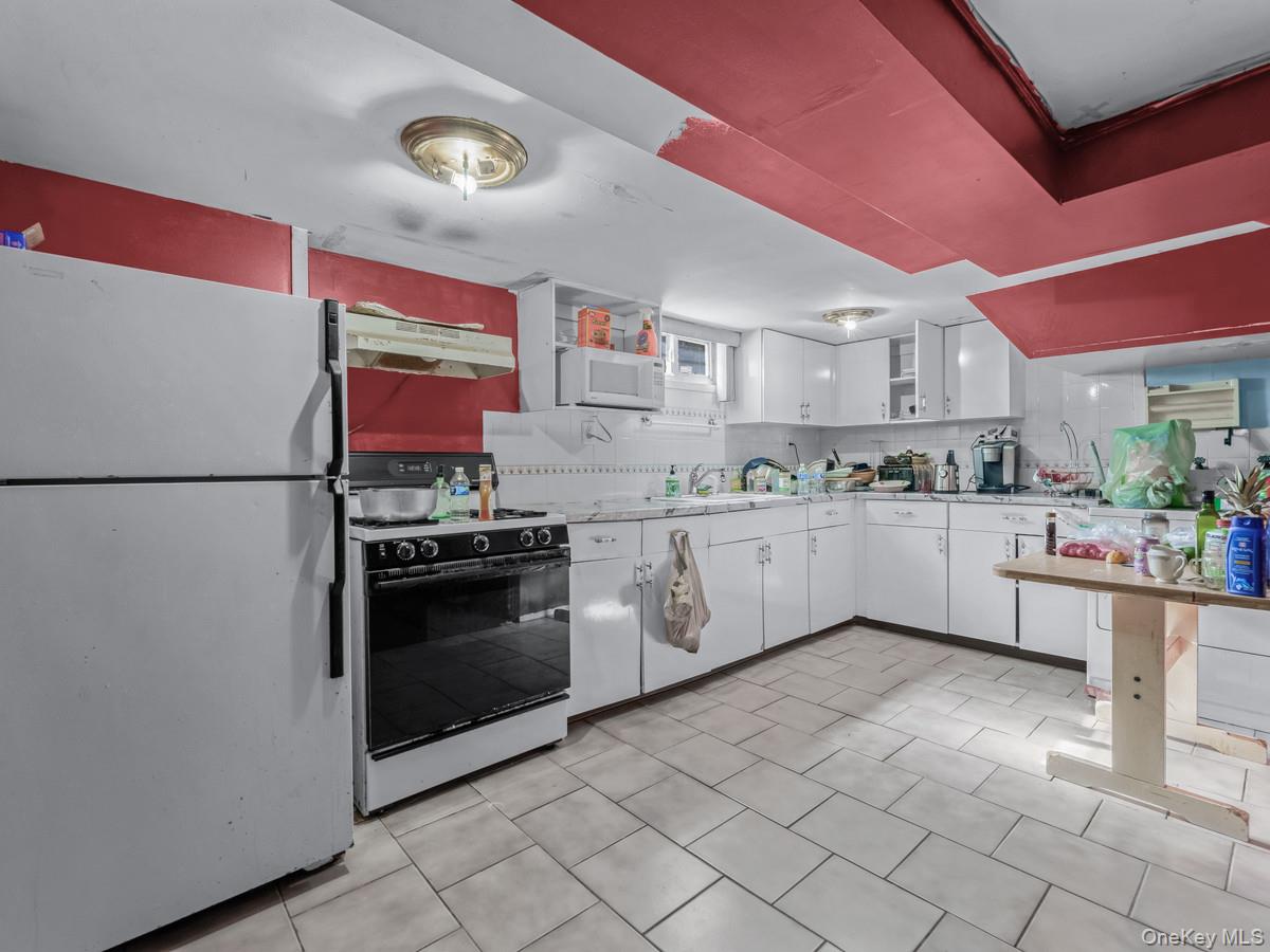 27-21 Coldspring Road Queens, NY 11691 - Photo 18 of 27 a kitchen with stainless steel appliances granite countertop a refrigerator sink and cabinets