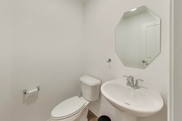 a bathroom with a sink a toilet and mirror
