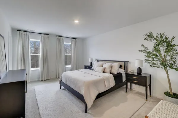 a bedroom with a large bed and a potted plant