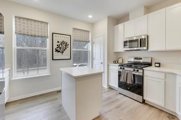 a kitchen with stainless steel appliances granite countertop a stove a sink and a microwave