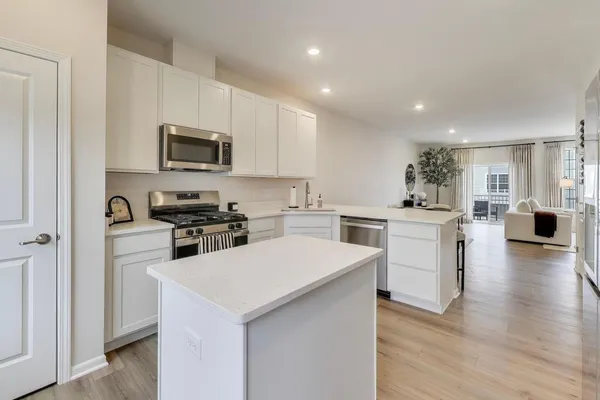 a kitchen with white cabinets and stainless steel appliances