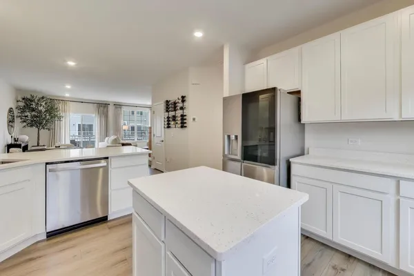 a kitchen with white cabinets and sink