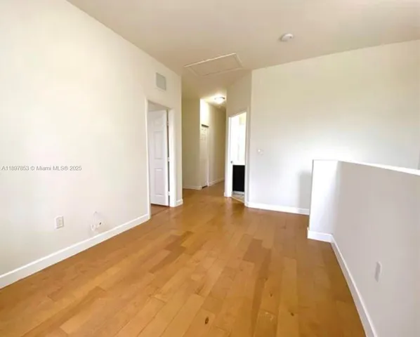 a view of empty room with wooden floor