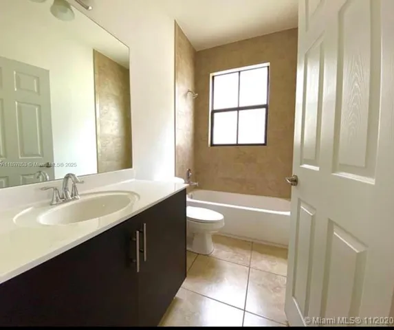 a bathroom with a double vanity sink toilet tub and mirror