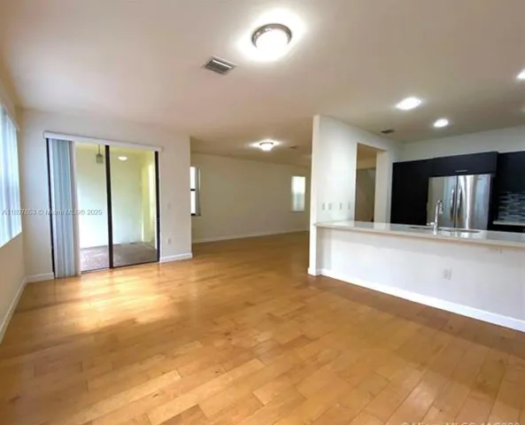 a view of an empty room with a kitchen