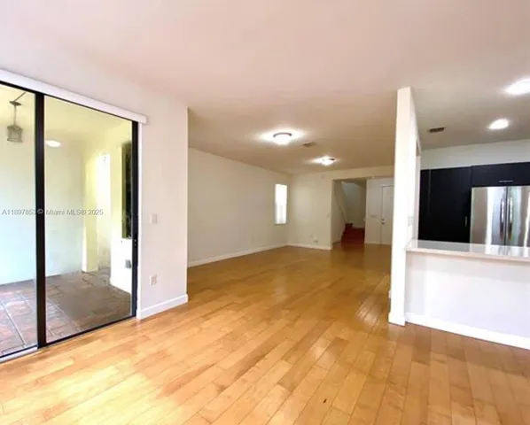 a view of a hallway with a dining table & chairs