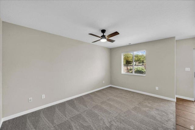 3155 South Hidden Dr Street, Unit 248 St. George, UT 84790 - Photo 8 of 24 Spacious room featuring neutral paint, gray patterned carpet, a ceiling fan with light, and a window with blinds