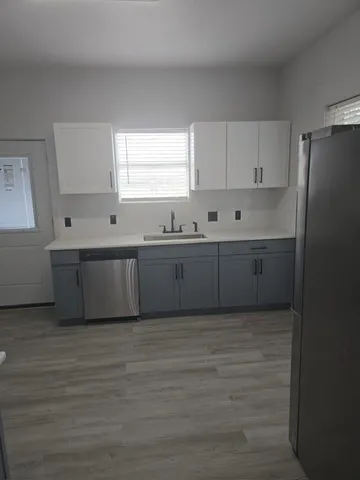 a large kitchen with window and cabinets