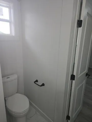 a white toilet sitting next to a window