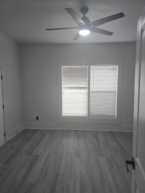 608 East Pecan Street Taylor, TX 76574 - Photo 18 of 25 a view of an empty room with a window and wooden floor