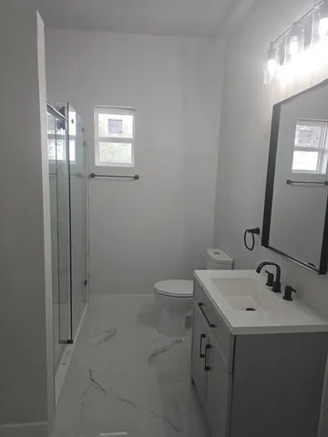 a bathroom with a sink a toilet and shower