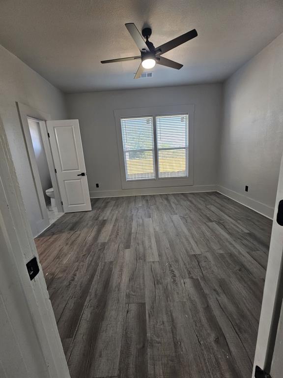 608 East Pecan Street Taylor, TX 76574 - Photo 23 of 25 wooden floor in an empty room with a window