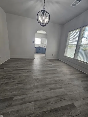 a view of empty room with wooden floor and window