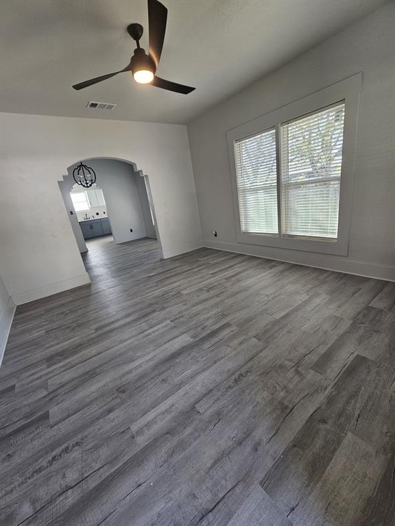 608 East Pecan Street Taylor, TX 76574 - Photo 6 of 25 an empty room with wooden floor chandelier and windows