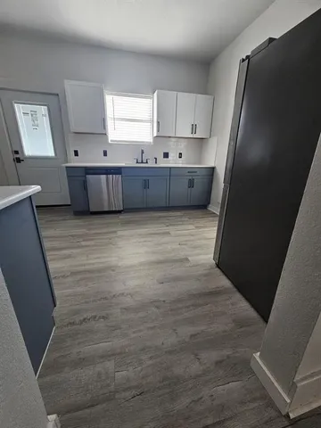 a view of kitchen with wooden floor and electronic appliances