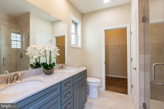 a bathroom with a granite countertop sink a toilet and shower