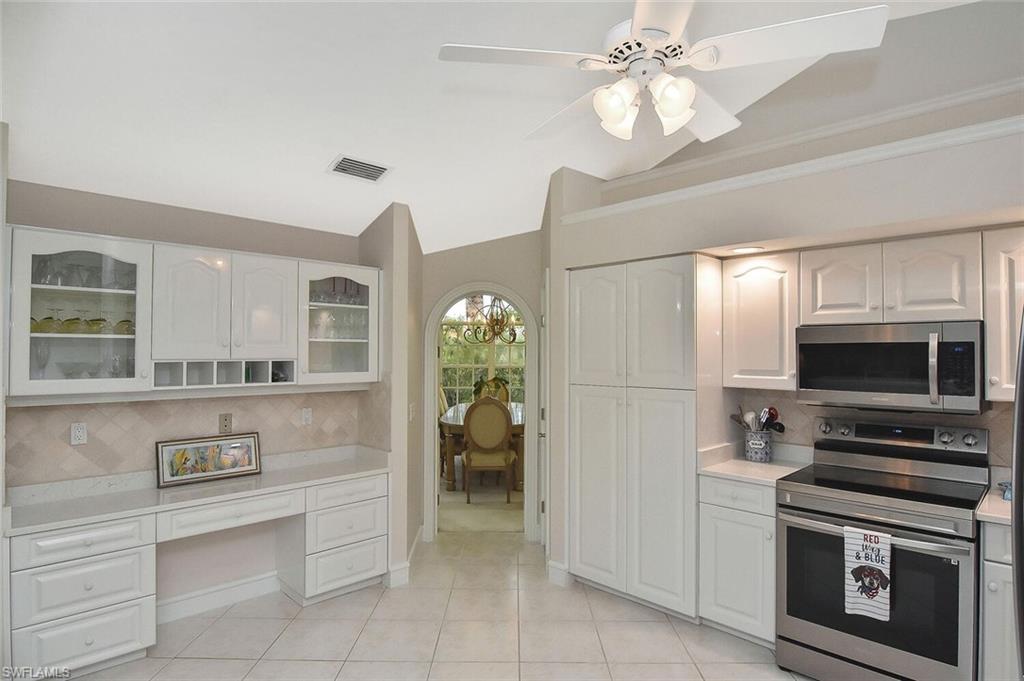 8928 Lely Island Circle Naples, FL 34113 - Photo 11 of 44 a kitchen with stainless steel appliances granite countertop a refrigerator and a stove top oven