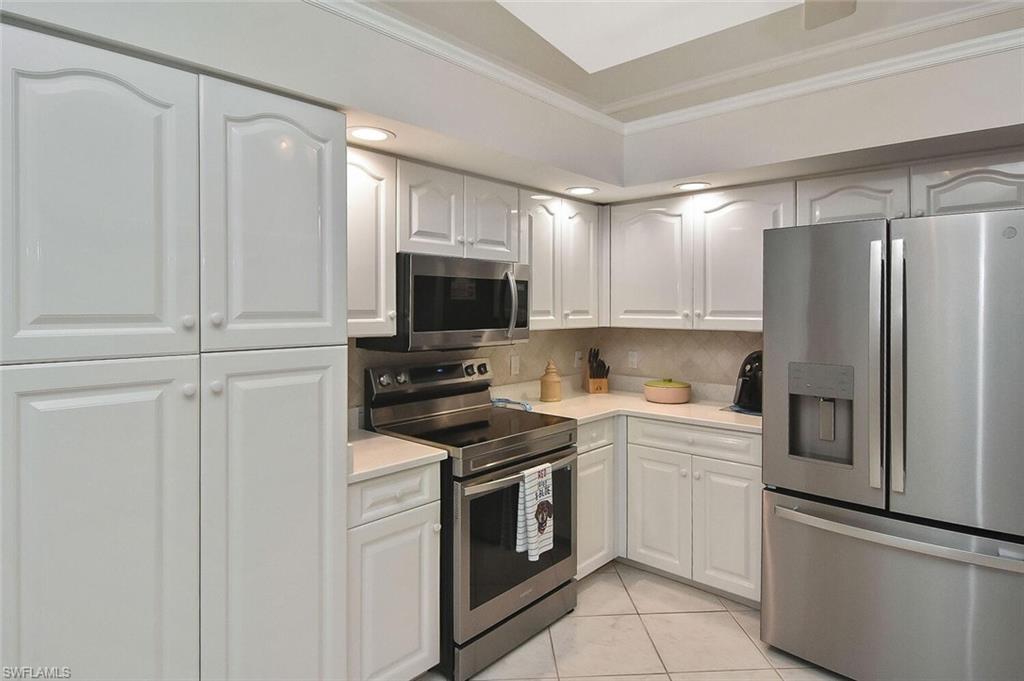 8928 Lely Island Circle Naples, FL 34113 - Photo 12 of 44 a kitchen with a refrigerator stove and microwave