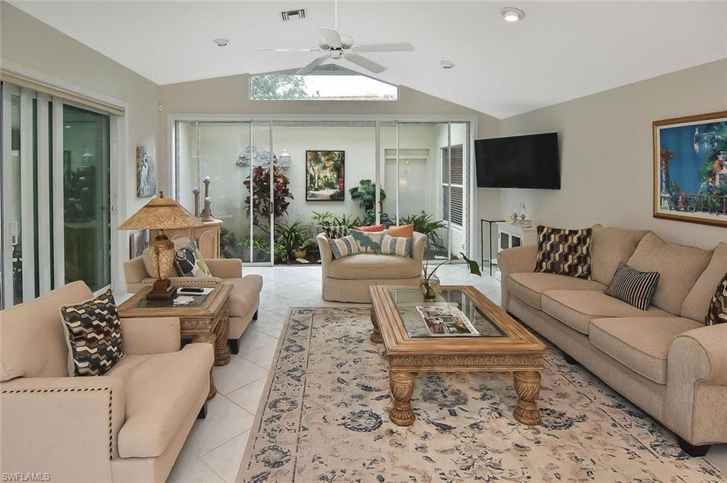 8928 Lely Island Circle Naples, FL 34113 - Photo 14 of 44 a living room with furniture and a flat screen tv