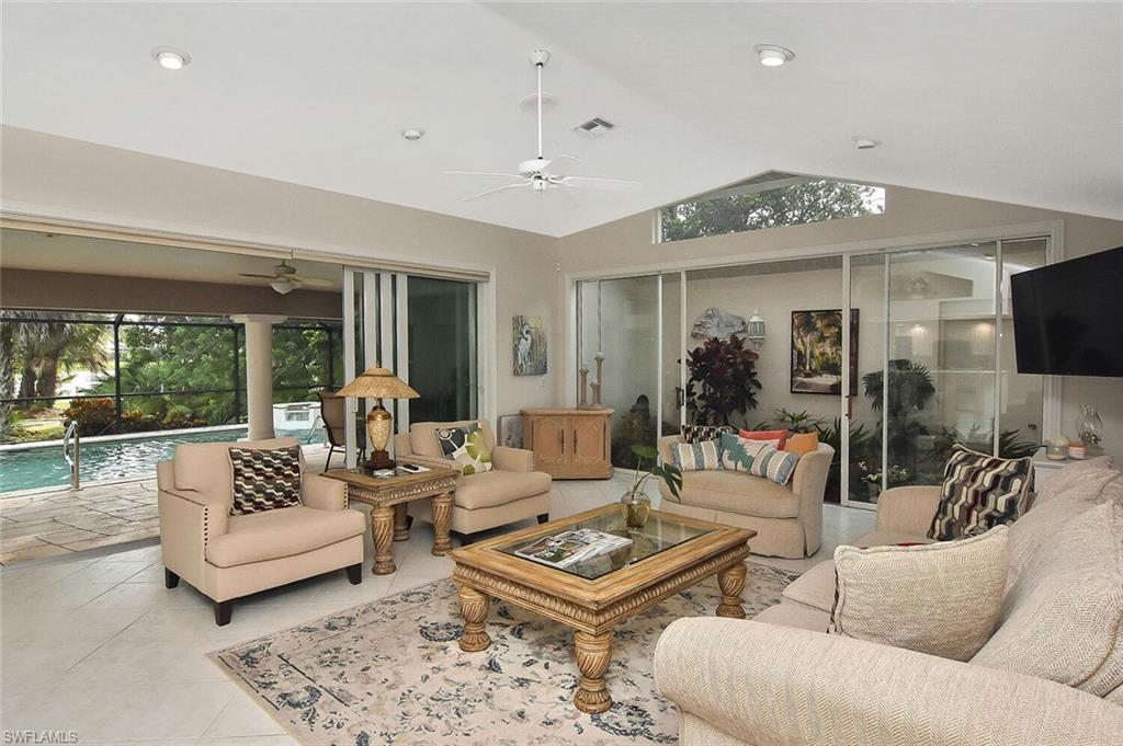 8928 Lely Island Circle Naples, FL 34113 - Photo 19 of 44 a living room with furniture ceiling fan and a rug