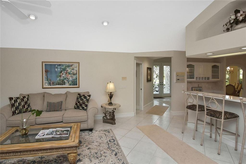 8928 Lely Island Circle Naples, FL 34113 - Photo 20 of 44 a living room with furniture a table and painting on the wall