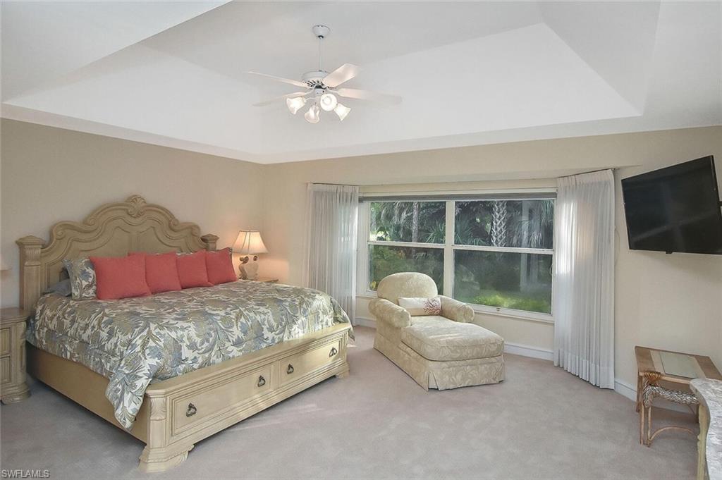 8928 Lely Island Circle Naples, FL 34113 - Photo 23 of 44 a bedroom with a bed and a flat screen tv