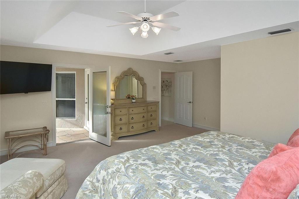 8928 Lely Island Circle Naples, FL 34113 - Photo 24 of 44 a bedroom with a bed and a flat screen tv