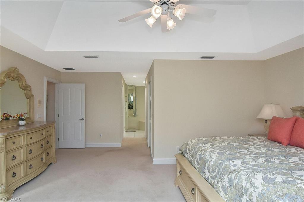 8928 Lely Island Circle Naples, FL 34113 - Photo 25 of 44 a bedroom with a bed and a chandelier
