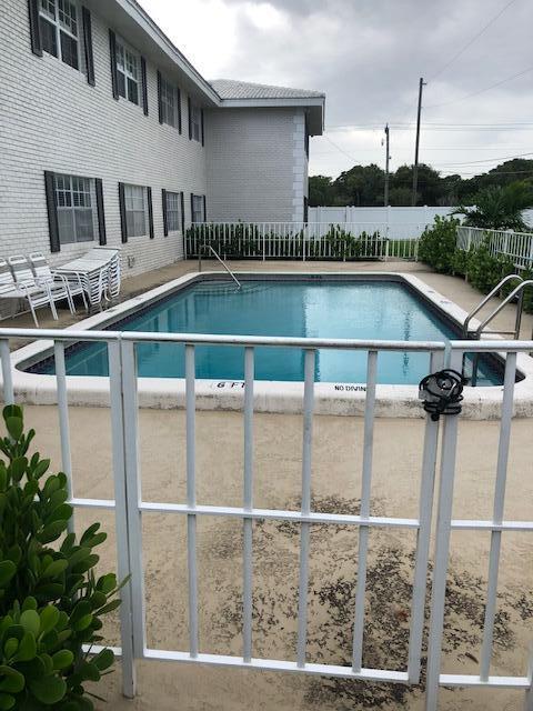 299 Southwest 7th Street, Unit 103 Boca Raton, FL 33432 - Photo 23 of 24 a front view of a house with a yard and balcony