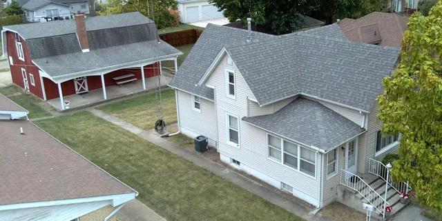 an aerial view of residential houses with yard and trees