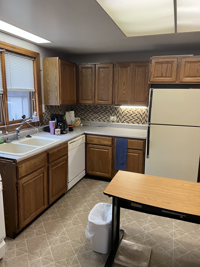 550 West Henry Street Kankakee, IL 60901 - Photo 9 of 31 a kitchen with a sink a stove cabinets and a dining table