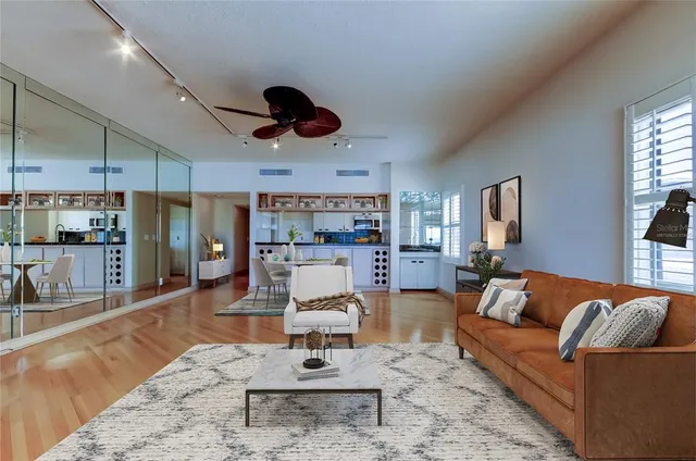 a living room with furniture kitchen view and a large window