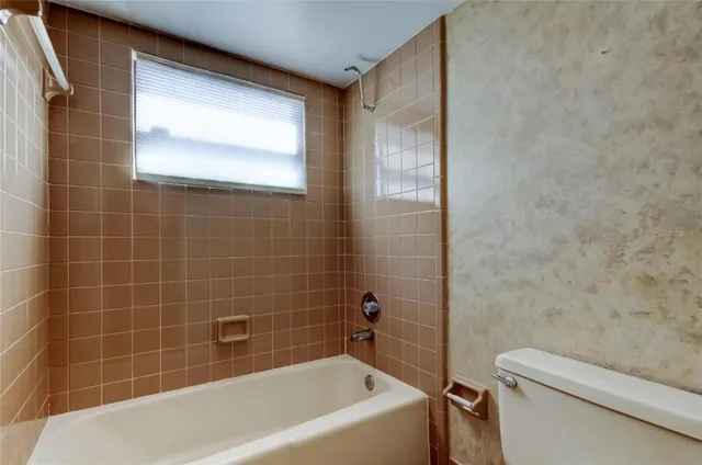 a spacious bathroom with a sink a toilet and a large mirror