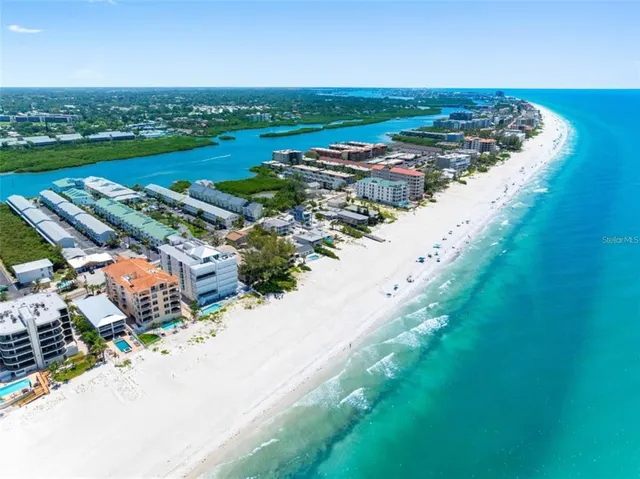 an aerial view of a city with lots of residential buildings ocean and mountain view in back