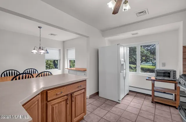 a kitchen with kitchen island a counter space a sink appliances and a window