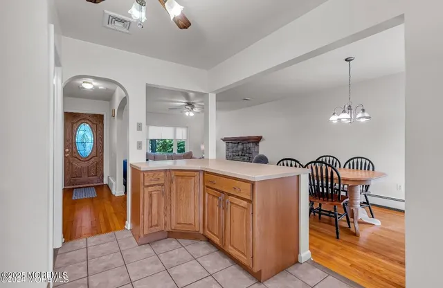 a kitchen with granite countertop cabinets a dining table and a chandelier