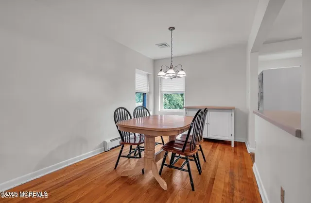 a view of a dining room with furniture wooden floor and chandelier