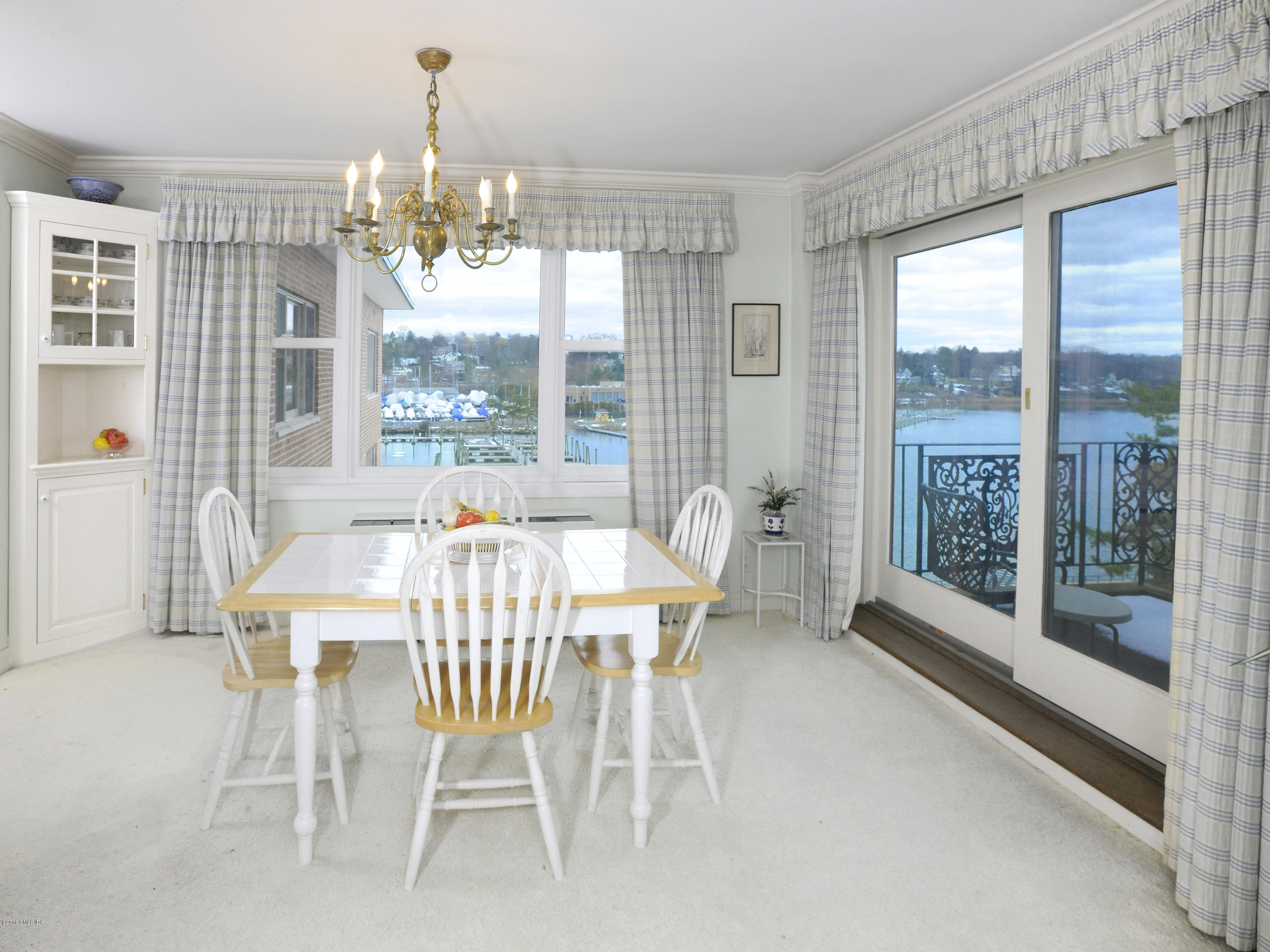 630 Steamboat Road, Unit 4D Greenwich, CT 06830 - Photo 8 of 11 a view of a dining room with furniture large windows and wooden floor