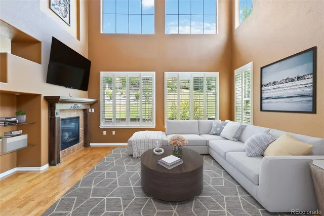 a living room with furniture a flat screen tv and a fireplace