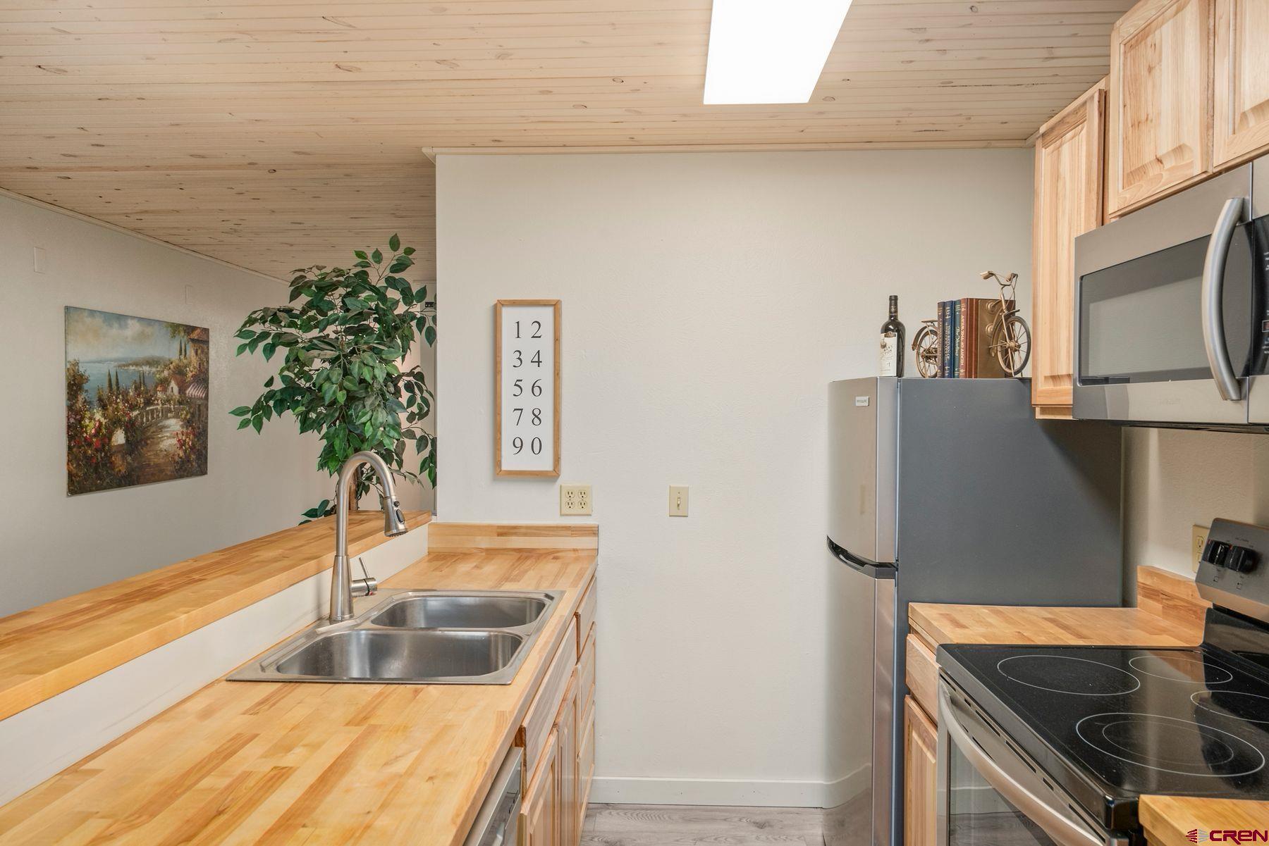 35 Emmons Road, Unit A Crested Butte, CO 81225 - Photo 6 of 28 a kitchen with stainless steel appliances granite countertop a sink a stove and a refrigerator