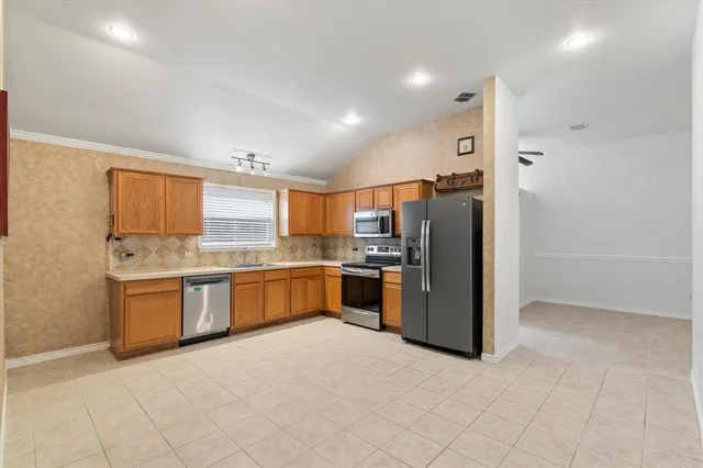 a large kitchen with stainless steel appliances a refrigerator and a stove top oven