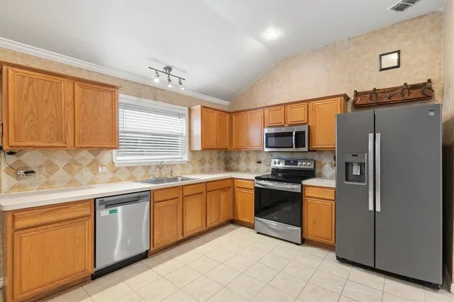 a kitchen with stainless steel appliances granite countertop a refrigerator and a stove top oven