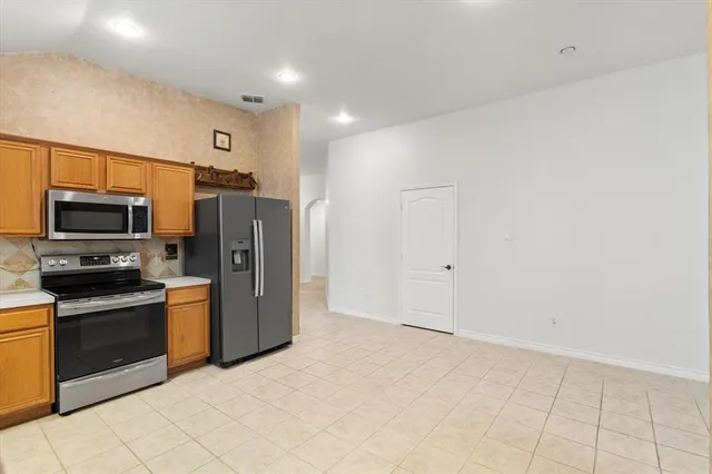 a kitchen with stainless steel appliances a refrigerator and a stove top oven