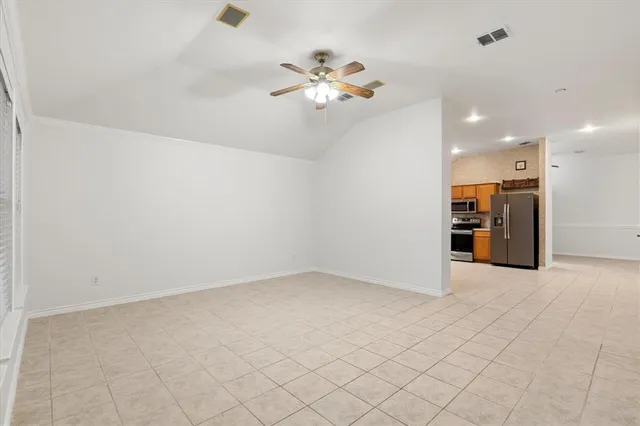 an empty room with kitchen and windows