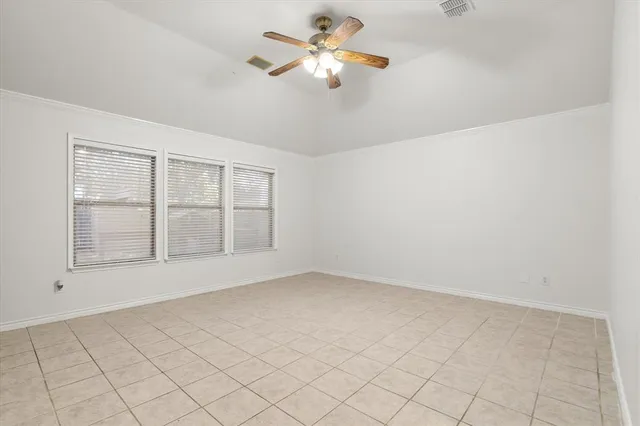 an empty room with chandelier fan